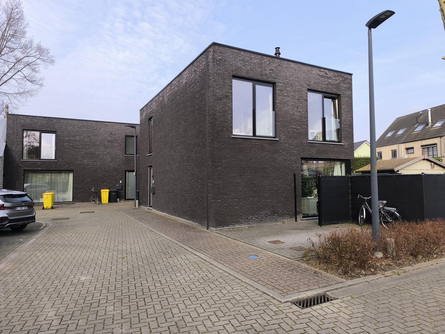 Moderne woning in donkere gevelsteen met grote raampartijen